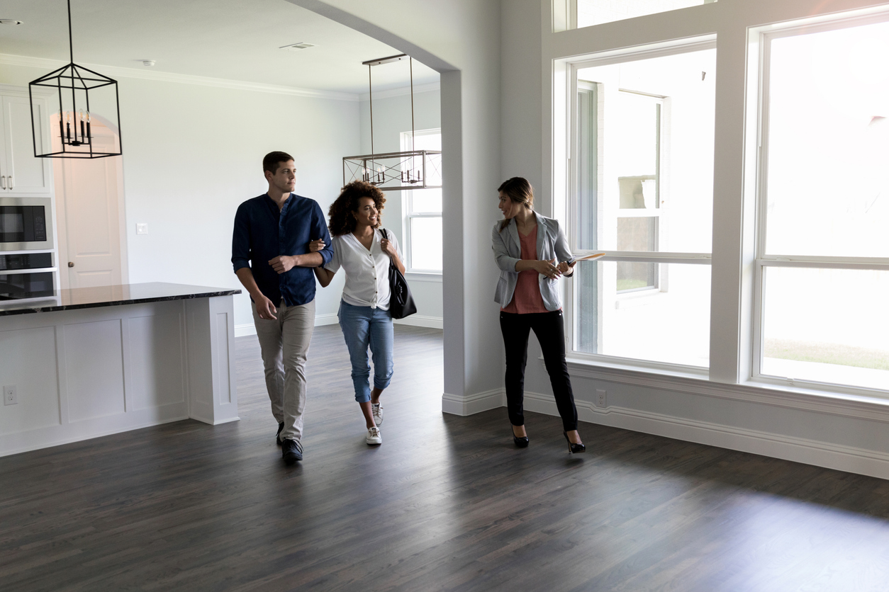 Real Estate Agent shows a couple a home. 